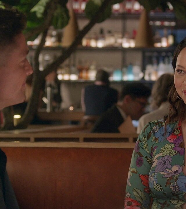 "The Rookie - Die Liste": Tim Bradford (Eric Winter) und Lucy Chen (Melissa O'Neil) sitzen sich an einem gedeckten Restauranttisch gegenüber und lächeln sich an.