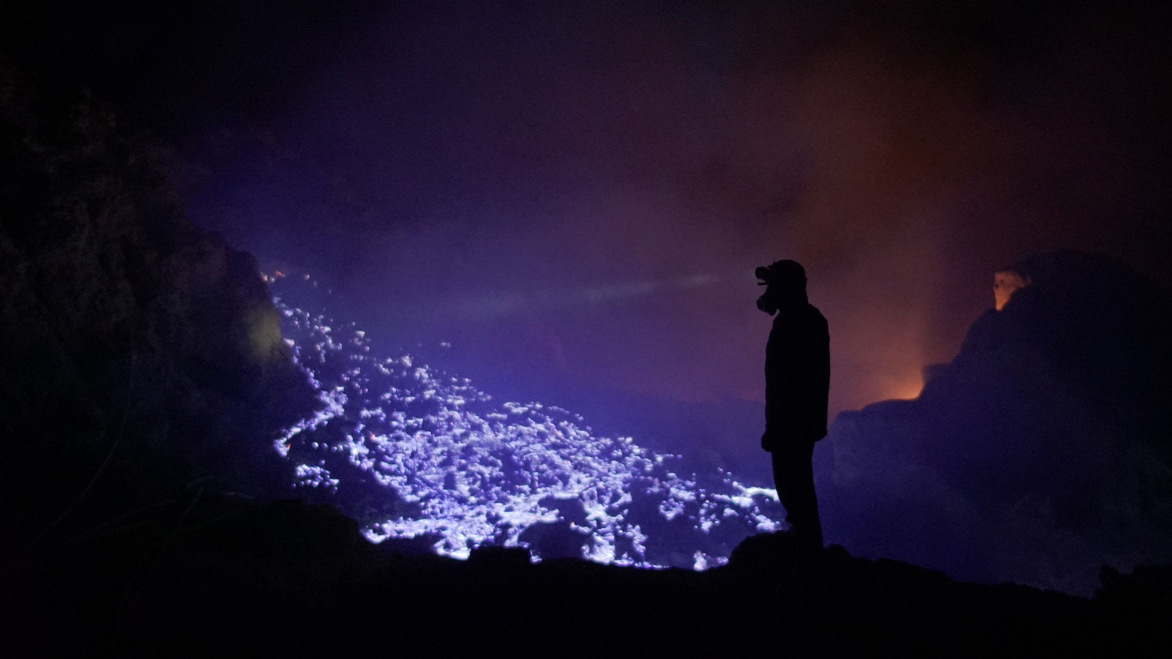 "Terra X: Fantastische Phänomene - 2. Bausteine des Lebens": Mann steht in einer dunklen Höhle vor blau-lila brennendem Schwefel.
