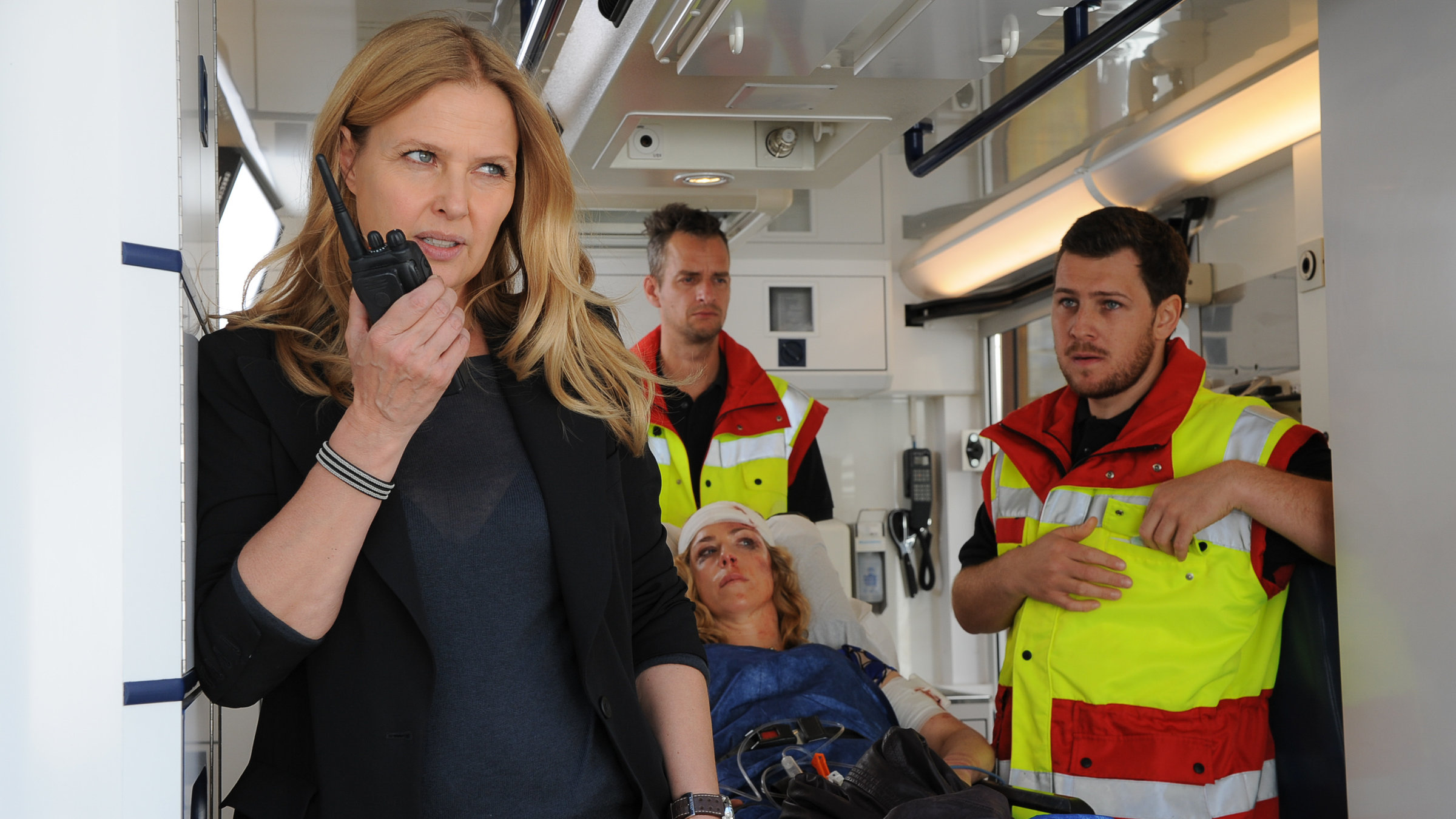 "Die Chefin – Das vierte Opfer“: Vera Lanz (Katharina Böhm) und das Opfer Sabine Heuchert (Brigitte Zeh) im Krankenwagen. Vera Lanz hält ein Funksprechgerät in der rechten Hand.