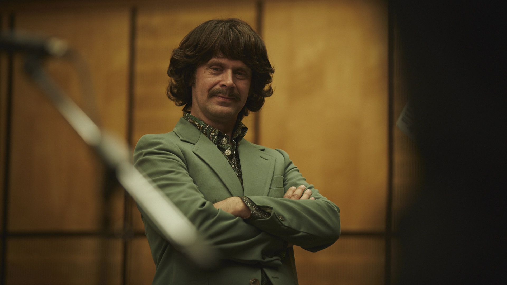 "Sketch History": Matthias Matschke als George Harrison. Sein Blick geht direkt in die Kamera, die Arme hat er vor dem Oberkörper verschränkt.