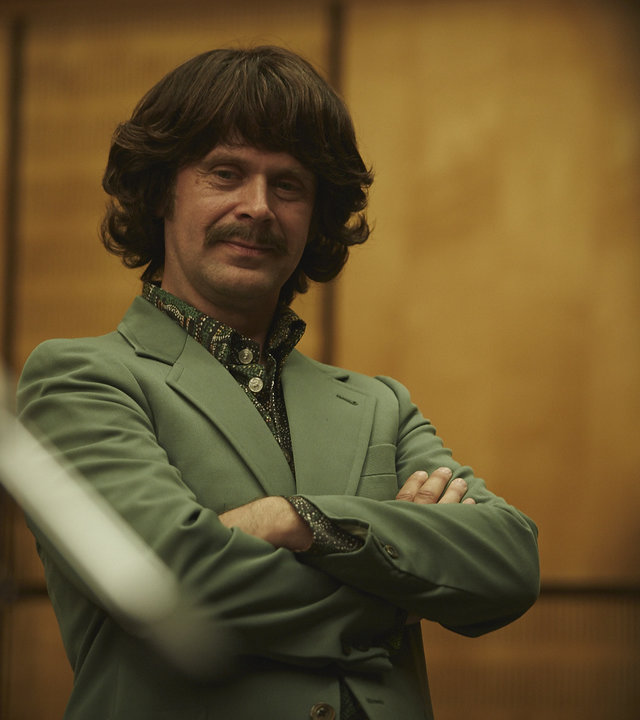 "Sketch History": Matthias Matschke als George Harrison. Sein Blick geht direkt in die Kamera, die Arme hat er vor dem Oberkörper verschränkt.