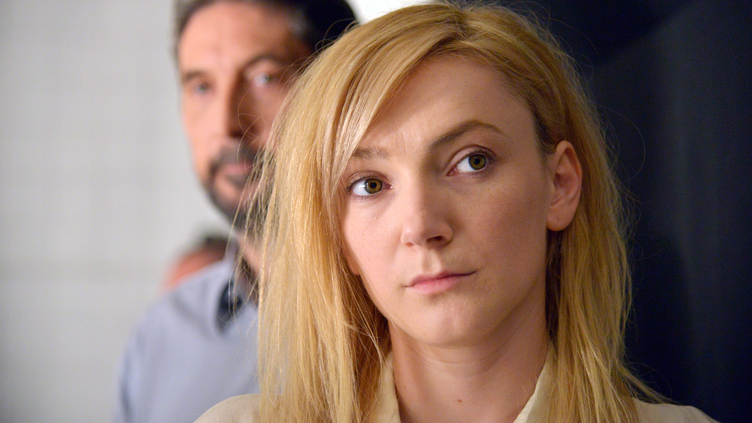 "Körper und Seele": Maria (Alexandra Borbély), eine junge Frau mit blonden, langen glatten Haaren, blickt nach vorne aus dem Bild. Hinter ihr ist leicht unscharf Endre (Géza Morcsányi), ein etwas älterer Mann mit angegrautem Bart, zu sehen.