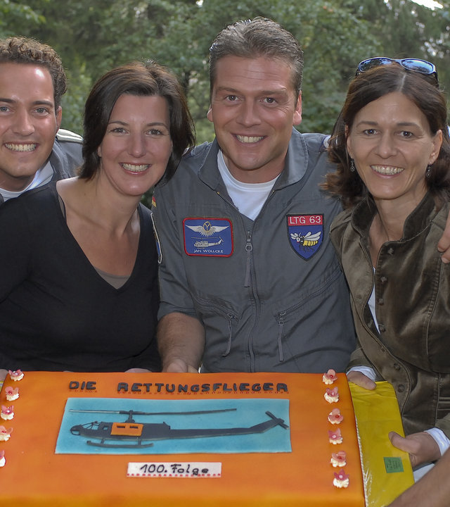 "Die Rettungsflieger": Das Team der Rettungsflieger hält gemeinsam eine Torte - darauf ist das Bild eines Hubschraubers zu sehen, darunter der Schriftzug "100. Folge".