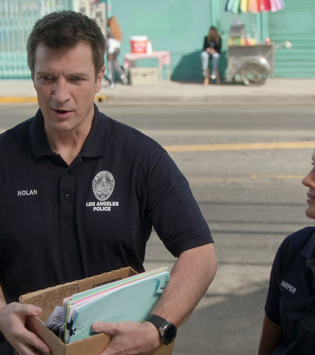 "The Rookie - Eine Frage des Gewissens": Nolan (Nathan Fillion) und Harper (Mekia Cox) stehen am Straßenrand und sprechen mit einer Person. Während Nolan die Person direkt anspricht, schaut Harper Nolan erstaunt an.