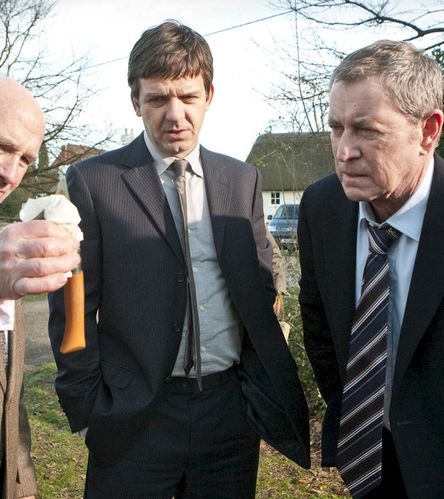 "Inspector Barnaby - Schreie in der Nacht": Außenaufnahme in einem Garten - Dr. George Bullard (Barry Jackson), DS Ben Jones (Jason Hughes) und DCI Tom Barnaby (John Nettles) begutachten eine Tatwaffe.
