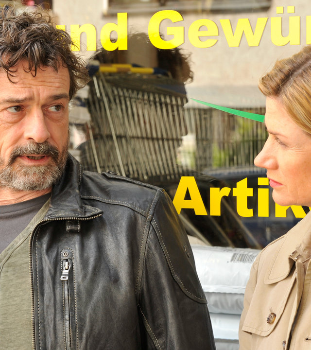"SOKO Stuttgart - Valentinstag": Martina Seiffert (Astrid M. Fünderich) und Dr. Emil Steinhausen (Thomas Sarbacher) stehen vor einem Laden und unterhalten sich.