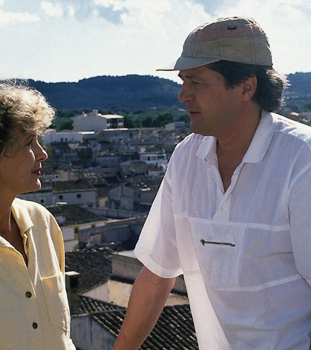"Der Landarzt - Urlaub zu zweit": Dr. Mattiesen (Christian Quadflieg) und Annemarie (Gila von Weitershausen) stehen nebeneinander vor einem Geländer und schauen sich konzentriert an. Im Hintergrund ist ein mallorquinisches Dorf zu sehen.