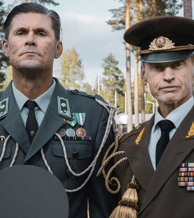 "Californian Commando - Die Überraschung": Major Miettinen (Tommi Korpela) und Major Poljakov (Andrei Tsumak) stehen in Paradeuniform aufrecht nebeneinander und schauen fokussiert geradeaus.