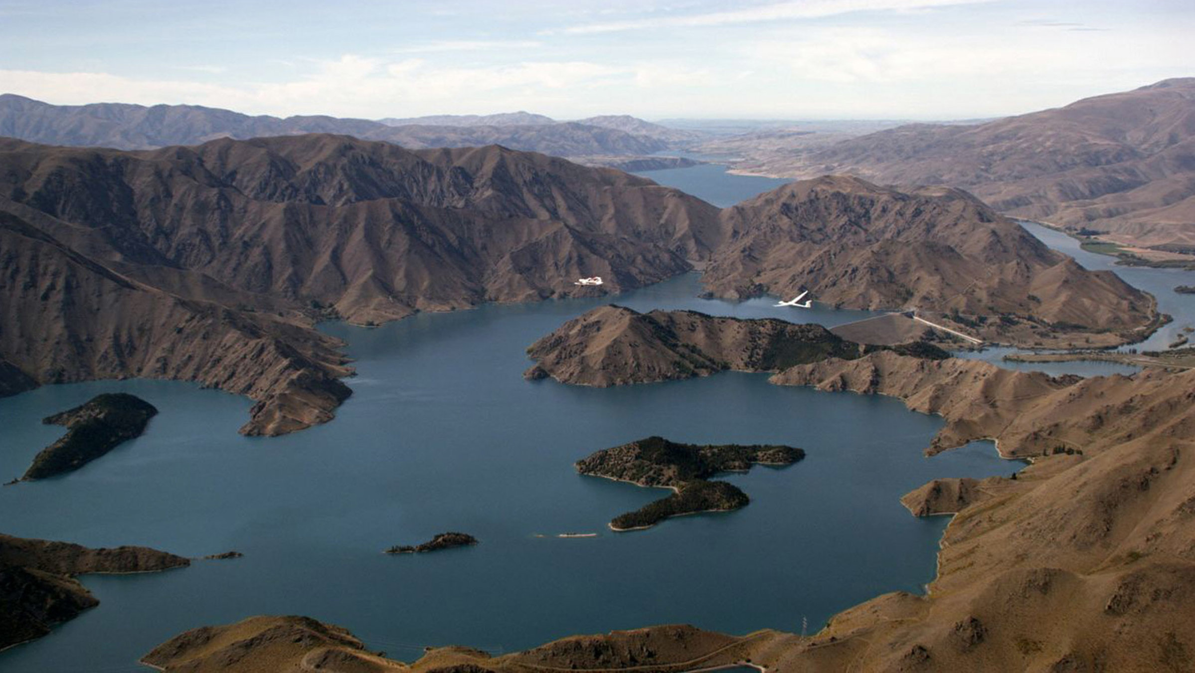 "Neuseeland von oben: Ein Paradies auf Erden - Die Südalpen": Flug über Lake Benmore kurz bevor das Zugflugzeug den Gleitflieger über den neuseeländischen Südalpen loslässt.
