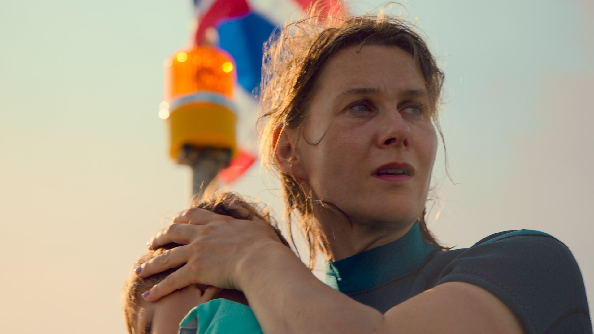"Die zweite Welle - Untiefen": Britta (Katrin Röver) drückt ihren Sohn Levin (Nanthapat Wiriyasombat) dicht an sich und blickt mit verstörter Miene vom Boot aus auf die Auswirkungen des Tsunamis.