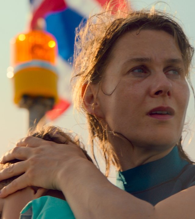 "Die zweite Welle - Untiefen": Britta (Katrin Röver) drückt ihren Sohn Levin (Nanthapat Wiriyasombat) dicht an sich und blickt mit verstörter Miene vom Boot aus auf die Auswirkungen des Tsunamis.