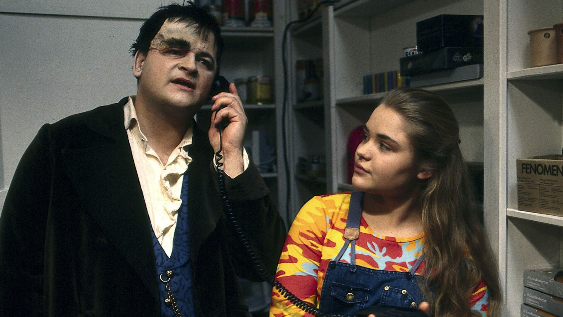 "Sprechstunde bei Dr. Frankenstein - Diese Mediziner!": Lenni (Michael Trischan) und Franzi (Floriane Eichhorn) stehen in einem Innenraum. Lenni telefoniert, Franzi schaut zu ihm.