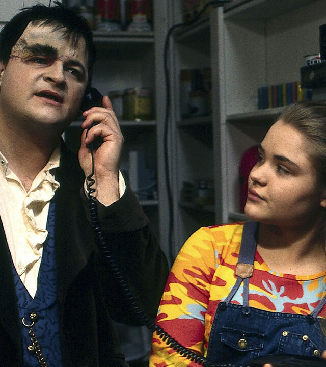 "Sprechstunde bei Dr. Frankenstein - Diese Mediziner!": Lenni (Michael Trischan) und Franzi (Floriane Eichhorn) stehen in einem Innenraum. Lenni telefoniert, Franzi schaut zu ihm.