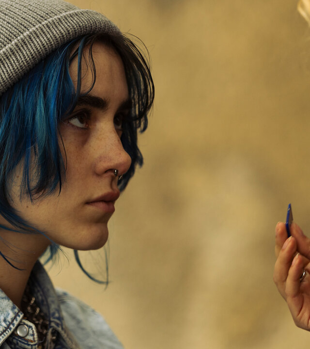 "Phoenix - Change Or Die: Alles brennt": Nina (Alva Schäfer) blickt zu Lyne (Pauline Pollmann), die nur im Anschnitt zu sehen ist. Diese hält Nina eine SD-Karte hinhält.