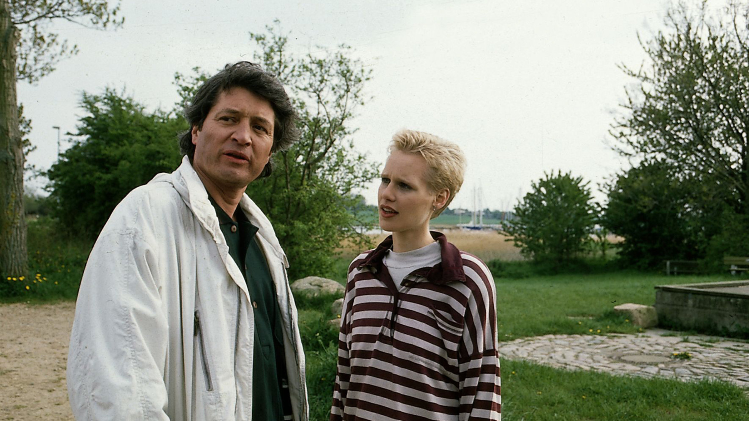 "Der Landarzt - Post aus Kanada": Dr. Mattiesen (Christian Quadflieg) und Kerstin (Katharina Lehmann) stehen gemeinsam in einem Park. Während Dr. Mattiesen gedankenvertieft in die Ferne schaut, sieht Kerstin zu ihm rüber.