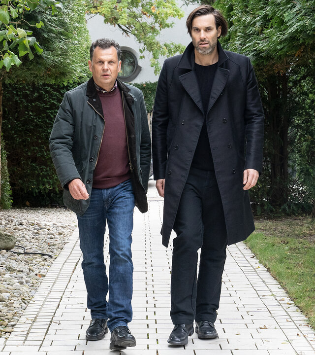"Laim und die Toten ohne Hosen": Anton Simhandl (Gerhard Wittmann) und Lukas Laim (Max Simonischek) laufen nebeneinander einen Weg entlang.