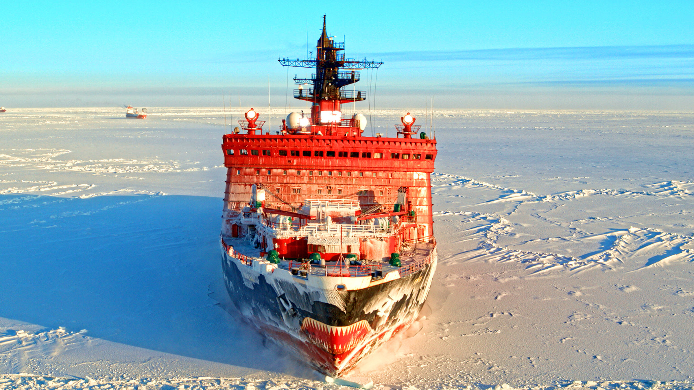"Terra X: Russland von oben - Sibirien und die weite Wildnis": Ein roter Eisbrecher auf dem zugefrorenen Nordpolarmeer. Blauer Himmel im Hintergrund.