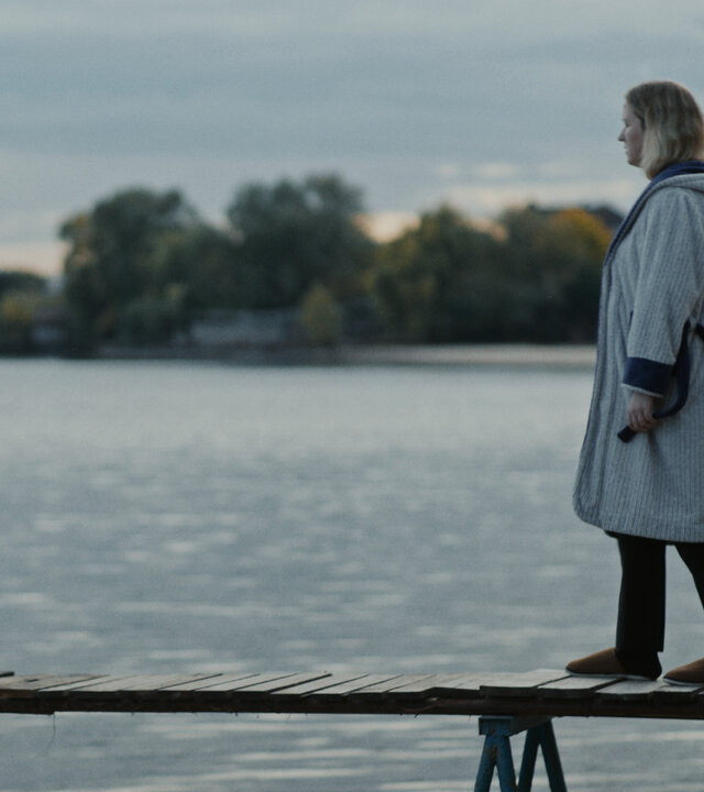 "In Her Car: Die Mutter, die zum Kuckuck wurde": Tamara (Lesia Ostrovska) geht über einen schmalen Steg. Unter ihr ist ein großes Gewässer.