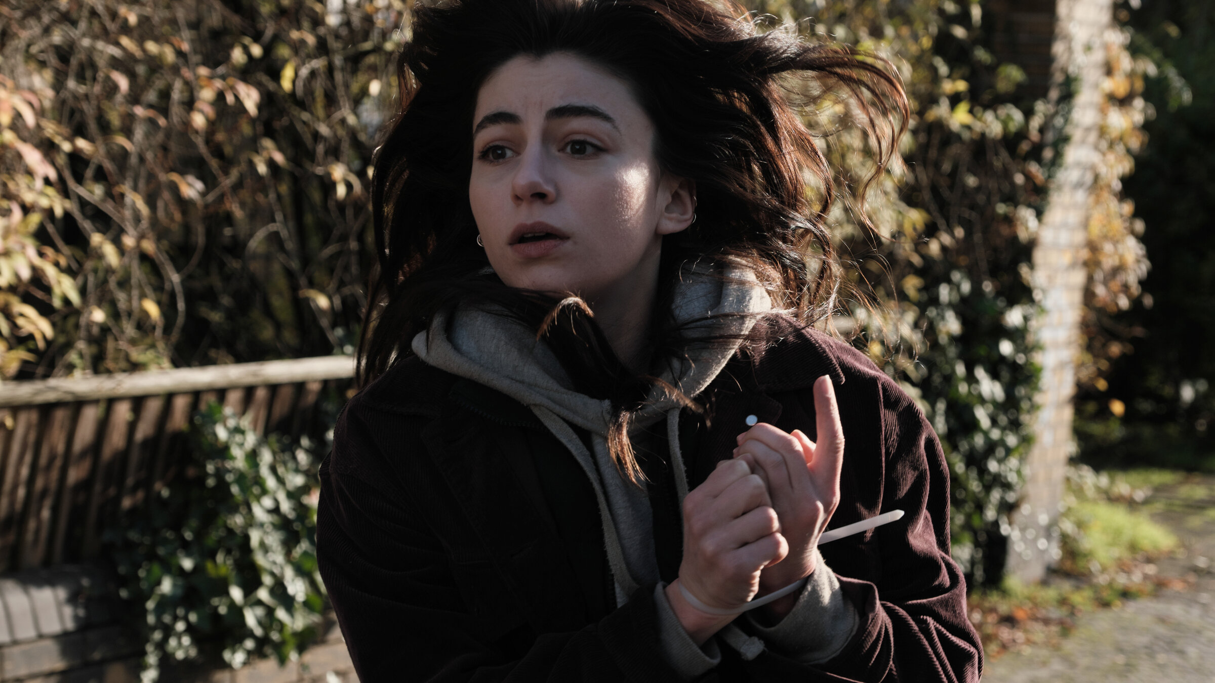 "Concordia - Tödliche Utopie (5) - Auf der Jagd": Elodie Cailleux (Alba Gaïa Bellugi) rennt mit gefesselten Händen an einem Garten vorbei.