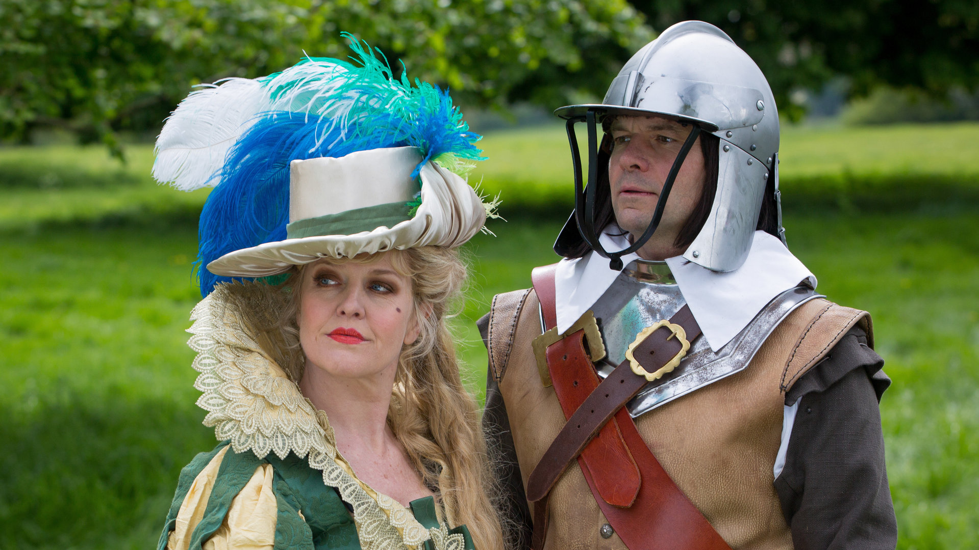 "Agatha Raisin – Und das Geisterhaus Teil 2": Agatha Raisin (Ashley Jensen) verkleidet als Dame zu Zeiten des Englischen Bürgerkriegs und James Lacey (Jamie Glover) verkleidet als Ritter stehen auf der Festwiese.