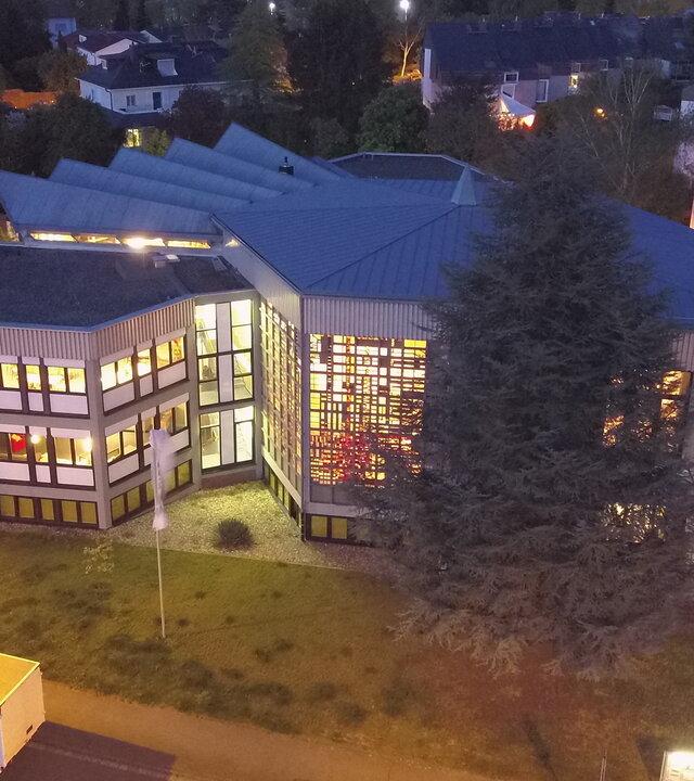 "Evangelischer Gottesdienst - Trau dich, zu vertrauen": Auf dem Bild ist die 1974 eingeweihte Christuskirche in Wiesbaden, auch Kirche überm Wellritztal genannt, von oben zu sehen. Es ist Abend, durch die vielen Fenster scheint das Licht aus dem sechseckigen Gottesdienstsaal und aus den Fenstern des angebauten Gemeindezentrums der deutschen Baptistengemeinde und der englischsprachigen International Baptist Church.