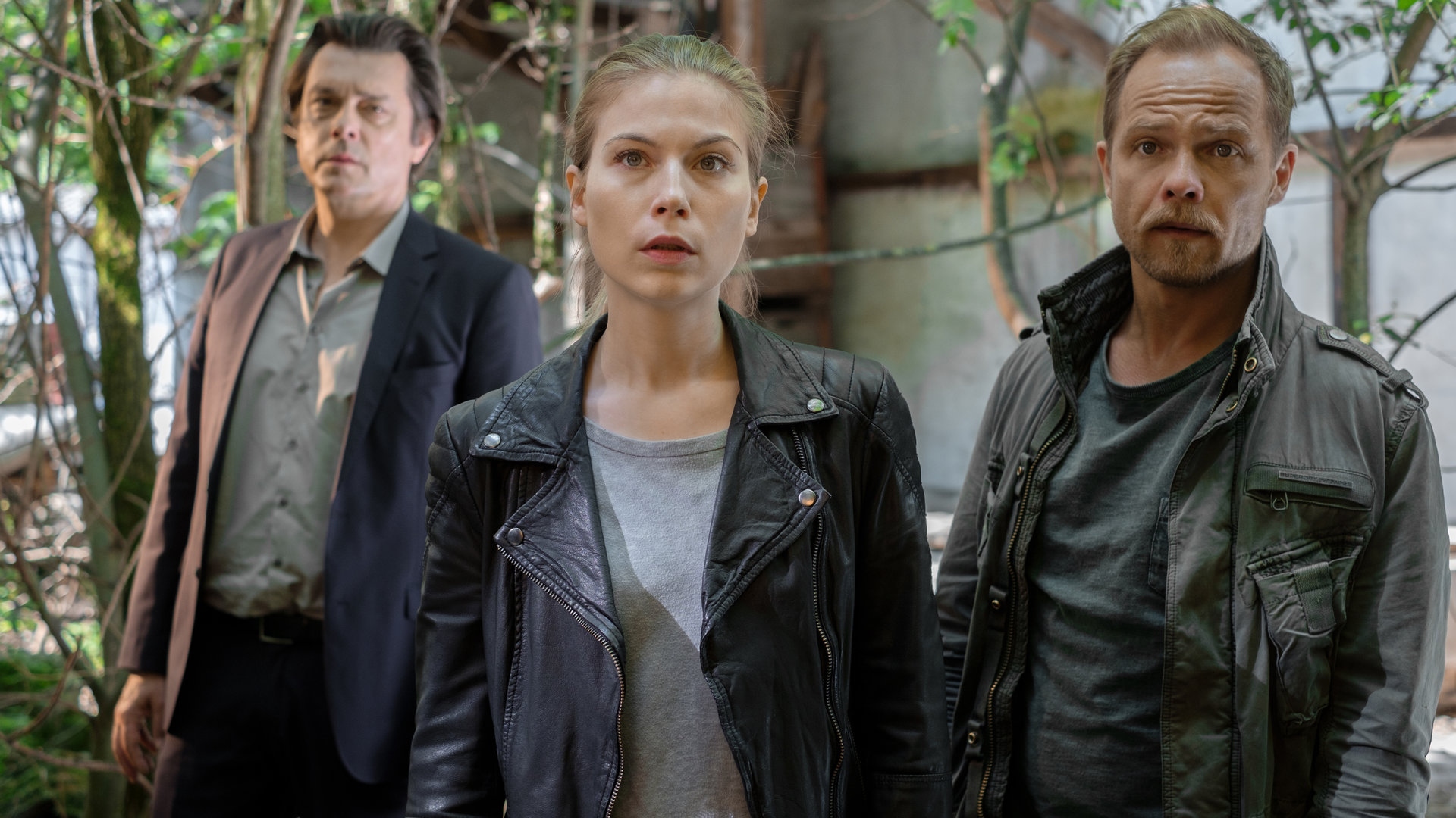 "Die Toten vom Bodensee - Die vierte Frau": Die drei Kollegen Komlatschek (Hary Prinz), Hannah Zeiler  (Nora Waldstätten) und Micha Oberländer (Matthias Koeberlin) stehen in einem Garten und schauen frontal in die Kamera.