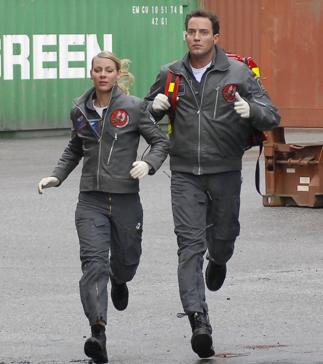 "Die Rettungsflieger - Schöne Aussichten": Sabine (Marlene Marlow)  und Jonny (Patrick Wolff) rennen mit der Notfallausrüstung durch den Containerhafen.