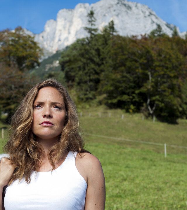 "Lena Lorenz - Willkommen im Leben (2)": Lena Lorenz (Patricia Aulitzky) steht auf einer Wiese vor einem Bergpanorama. Sie blickt nachdenklich in die Ferne.
