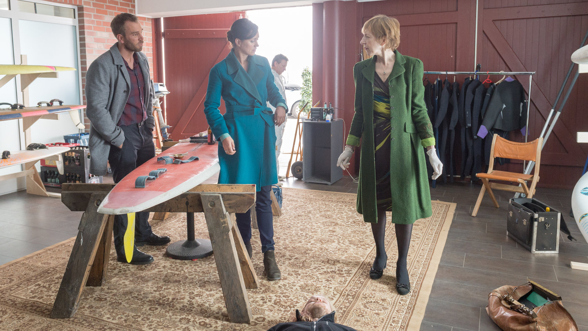 „SOKO Wismar – Der schöne Finn“: Helene Sturbeck (Katharina Blaschke) zeigt ihren Kollegen Karoline Joost (Nike Fuhrmann) und Lars Pöhlmann (Dominic Boeer) den toten Surflehrer Finn Hoffmann (Philipp Czech), der tot in seiner Surfschule liegt.