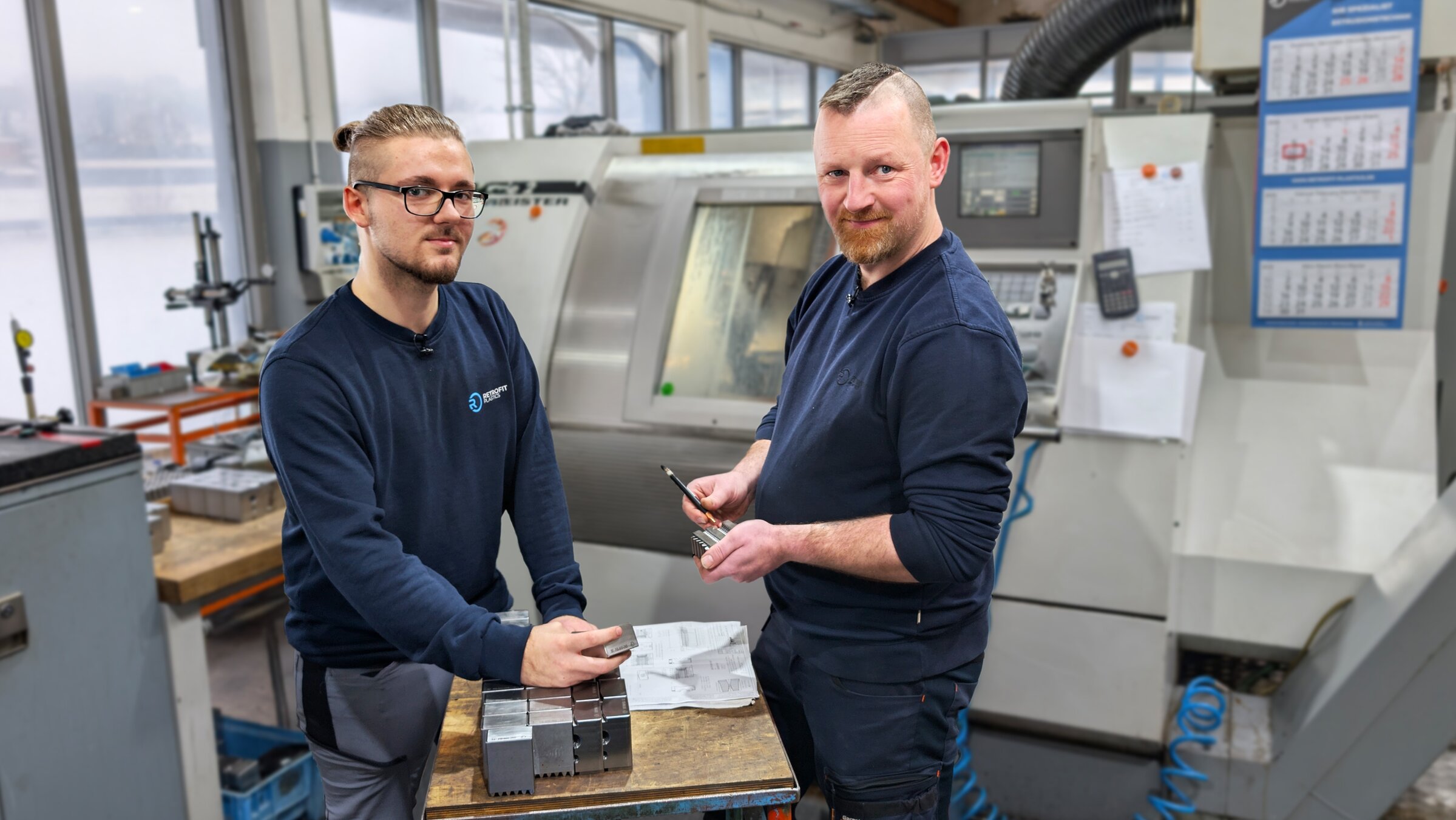"ZDF.reportage: Azubi-Krise -  Handwerker schlagen Alarm": Ausbilder Markus Mittelsdorf und sein Lehrling Carlos stehen in einem Werkraum vor der CNC-Fräse.
