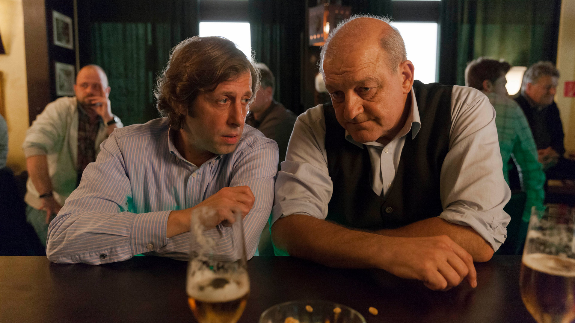 "Wilsberg - Das Geld der anderen": Ekki (Oliver Korittke) und Wilsberg (Leonard Lansink) sitzen an einer Theke und unterhalten sich.