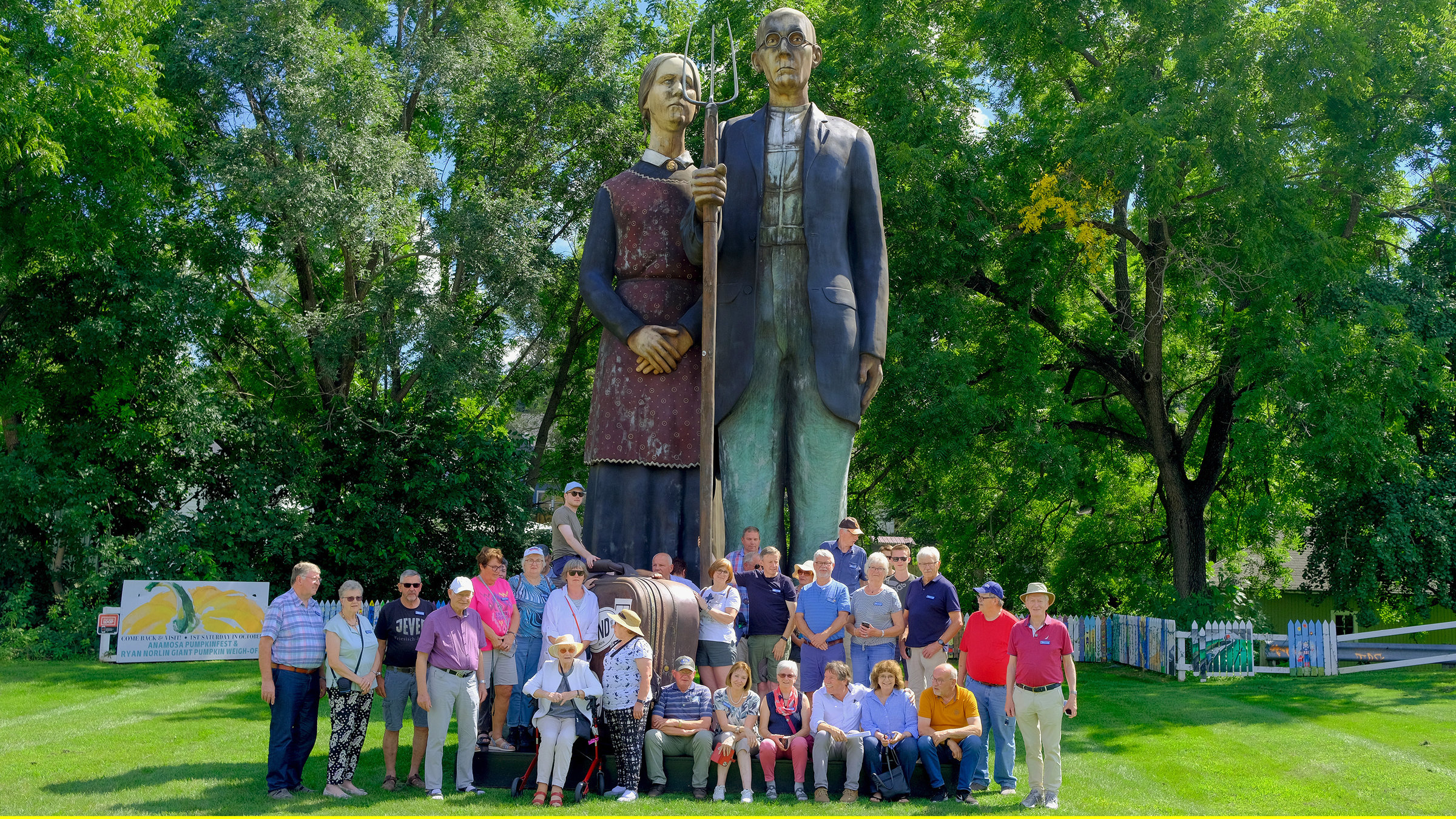 "Dibaba in Amerika - 2000 Meilen - Die großen Seen": Die Reisegruppe in Anamosa Iowa vor einer Skulptur zur Erinnerung an den Künstler Grant Wood.