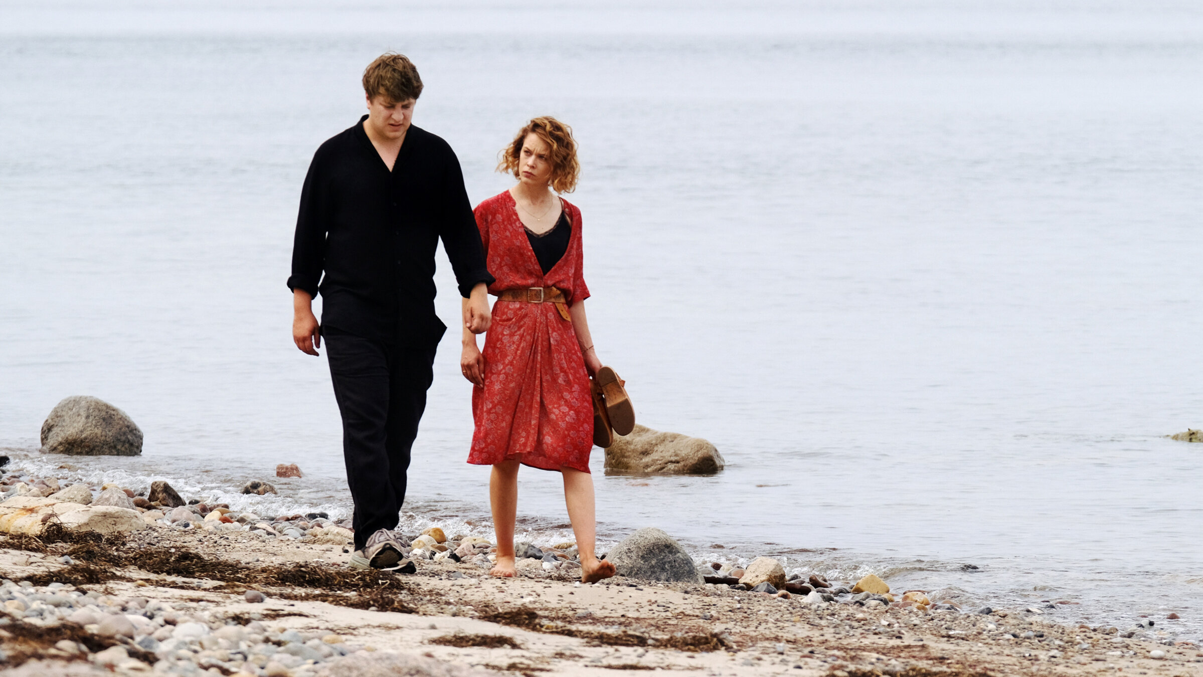 "Roter Himmel": Leon (Thomas Schubert) und Nadja (Paula Beer) laufen nebeneinander am Strand entlang.