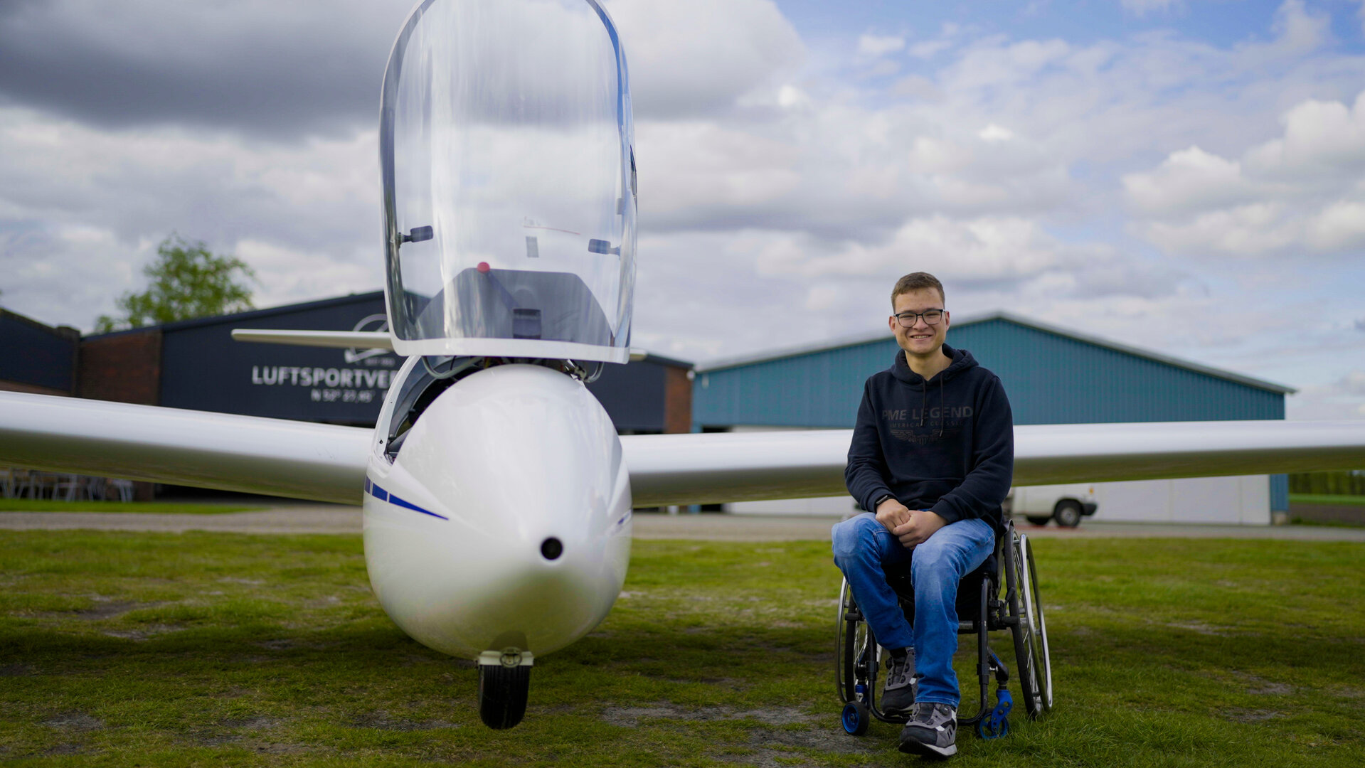 "einfach Mensch - Der Traum vom Fliegen: Jonathan Teupen (1)": Jonathan Teupen sitzt im Rollstuhl neben einem Segelflugzeug.