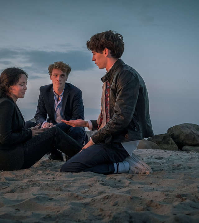 "Das Mädchen am Strand (2)": Jule Reinhardt (Tijan Marei), Jakob Bruns (Bruno Alexander), David Jung (Oskar Belton) sitzen zusammen am Strand.