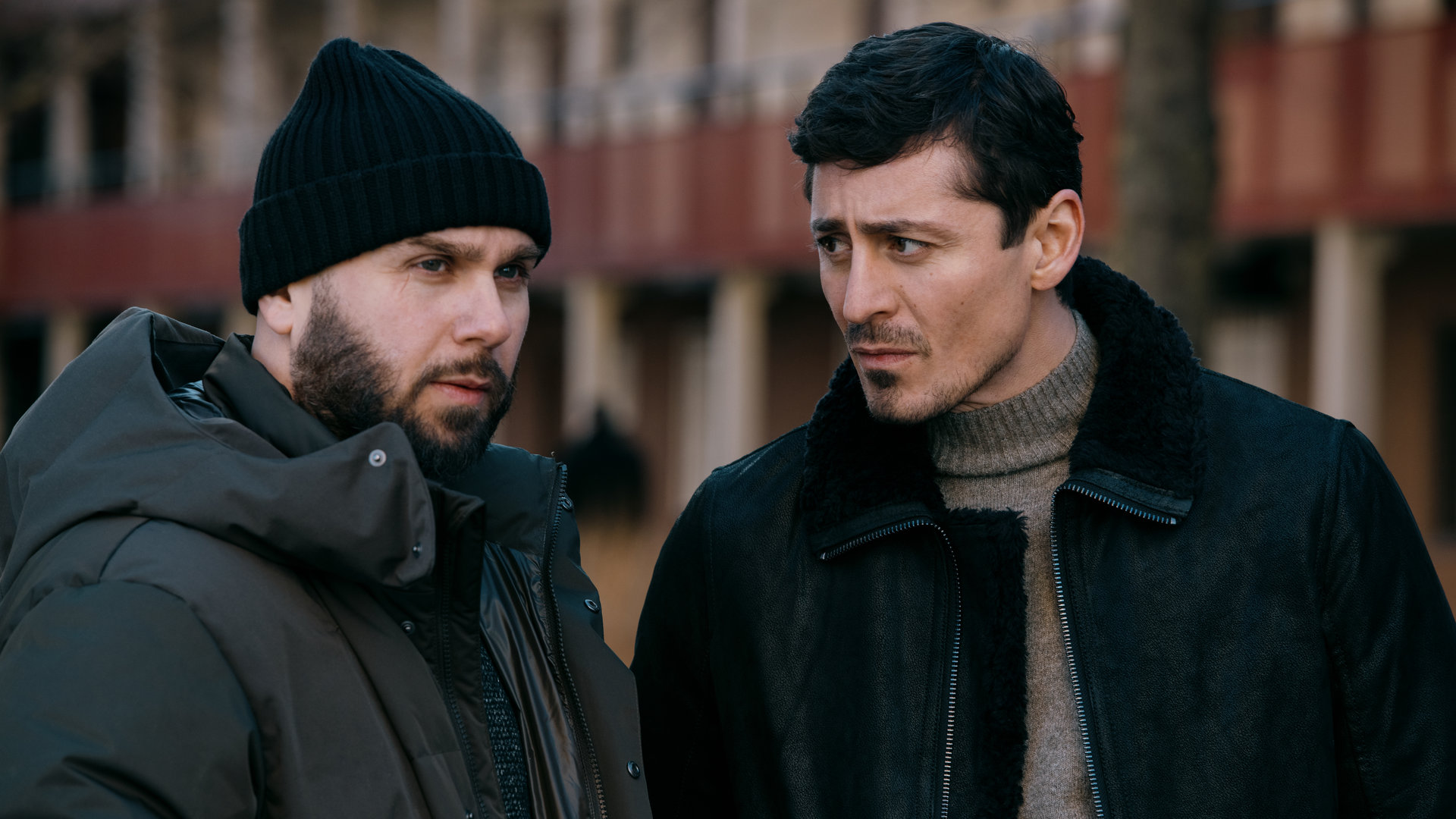 "Hidden Agenda II: Der Cousin": Johnny (Pablo Leiva Wenger) und Teddy (Alexej Manvelov) stehen nebeneinander vor einem Gebäude. Teddy blickt seinen Kumpel skeptisch an.