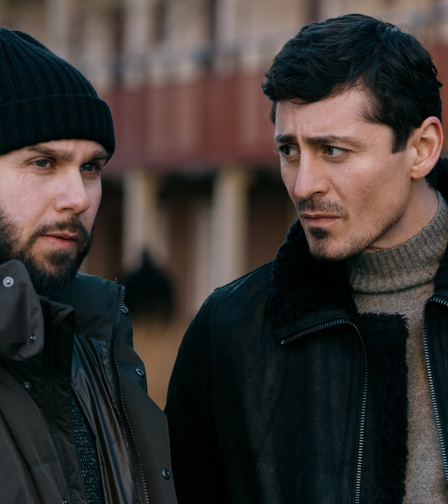 "Hidden Agenda II: Der Cousin": Johnny (Pablo Leiva Wenger) und Teddy (Alexej Manvelov) stehen nebeneinander vor einem Gebäude. Teddy blickt seinen Kumpel skeptisch an.