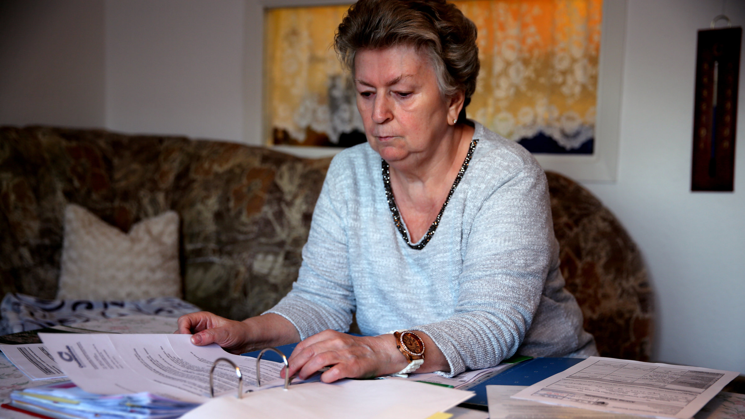 "ZDF.reportage: Deutschland, Deine Ämter - Die Betreuer vom Sozialamt": Brigitte N. sitzt in ihrem Wohnzimmer vor einem Aktenordner.