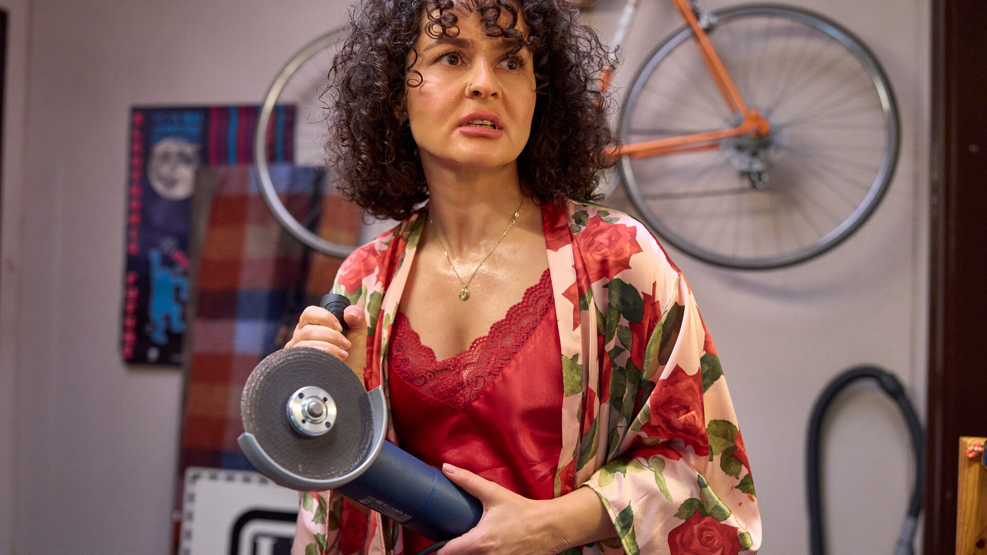 "Ich dich auch! - Der Stichtag": Jackie (Nagmeh Alaei) steht im Spitzennachthemd völlig aufgelöst im Raum. Sie hält eine Schneidemaschine in den Händen.