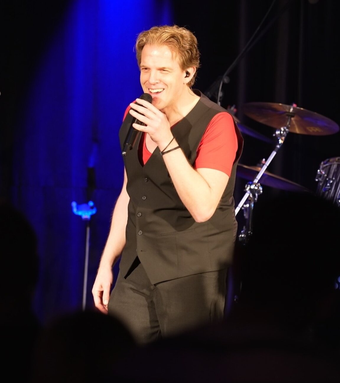 "ZDF.reportage: Der schwere Weg zum Traumjob": Karl Frenzel auf der Bühne mit einem Mikrofon in der Hand.