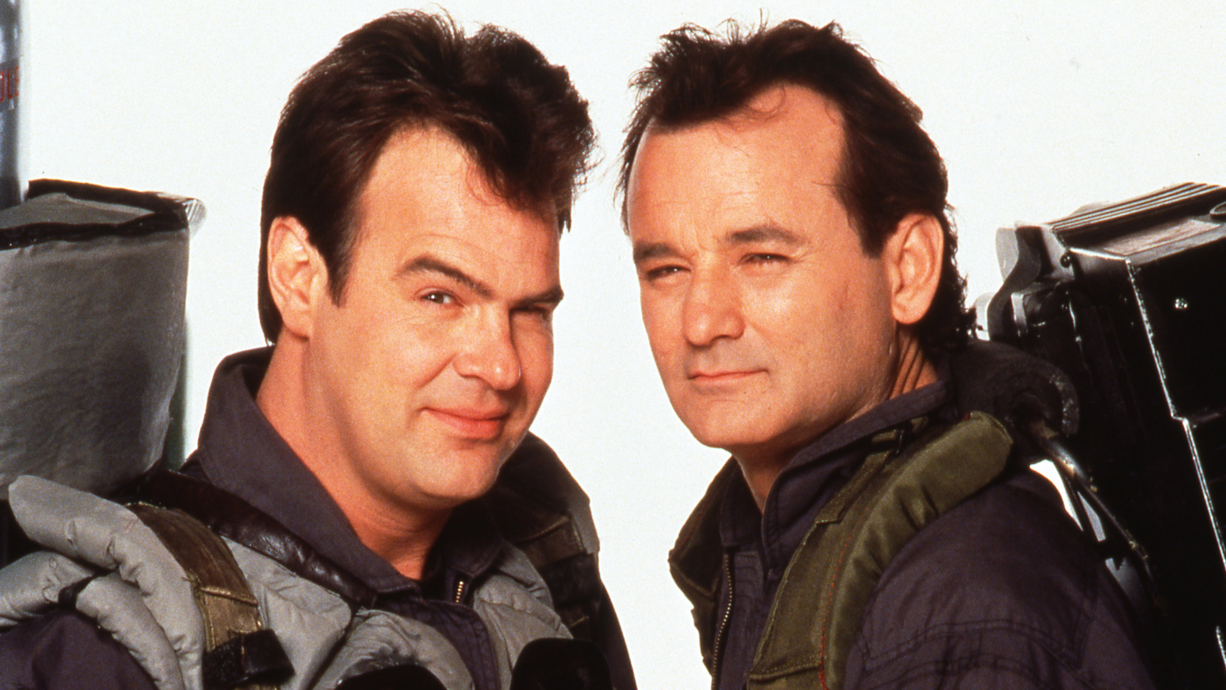 "Ghostbusters II": Peter Venkman (Bill Murray) und Ray Stantz (Dan Aykroyd) stehen nebeneinander und schauen mit zusammen gekniffenen Augen in die Kamera.