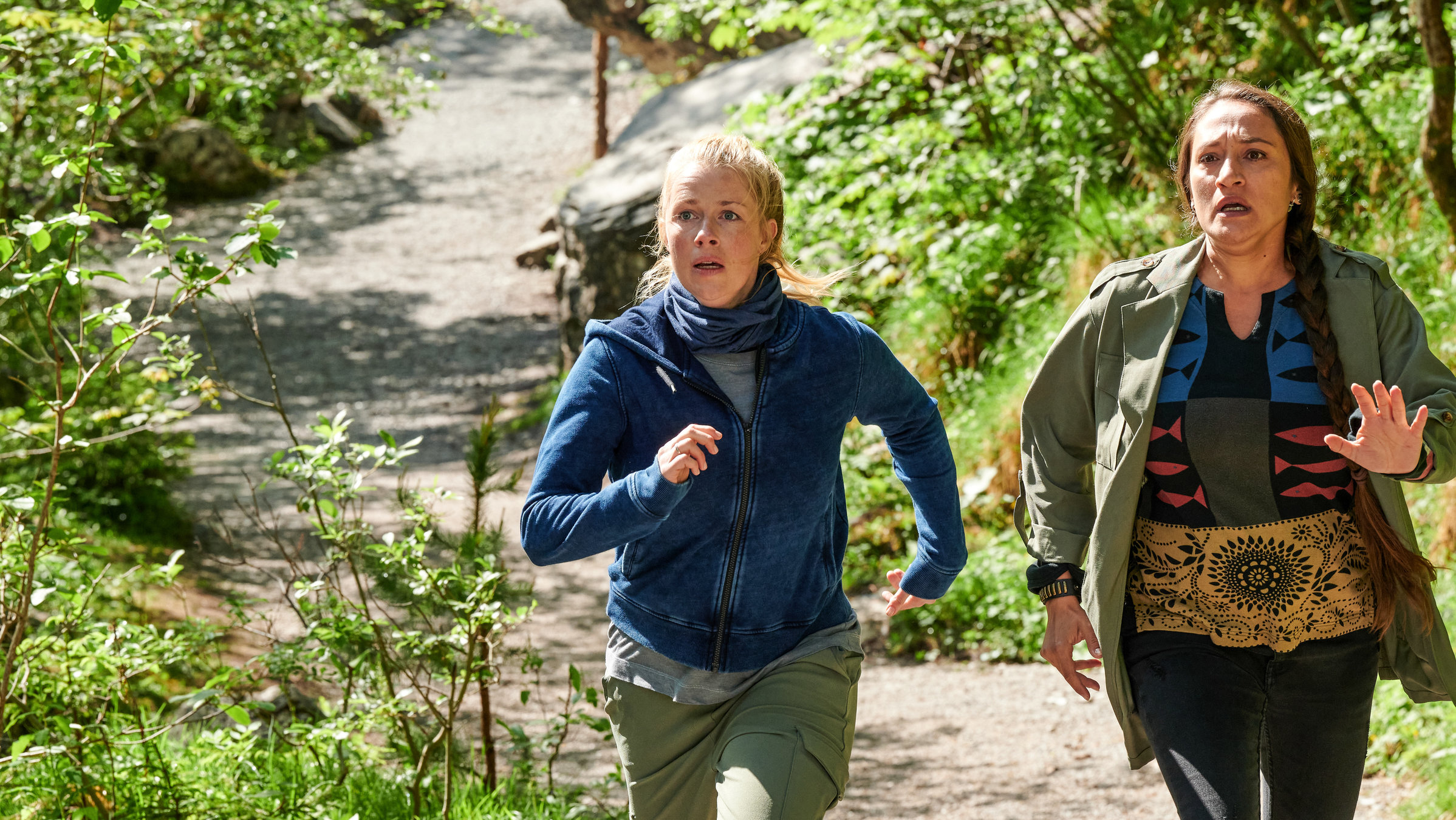 "Marie fängt Feuer - Ungewisse Zukunft": Tamara Berger (Lo Rivera) und Marie (Christine Eixenberger) rennen nebeneinander einen Waldweg hinauf und blicken besorgt nach oben.