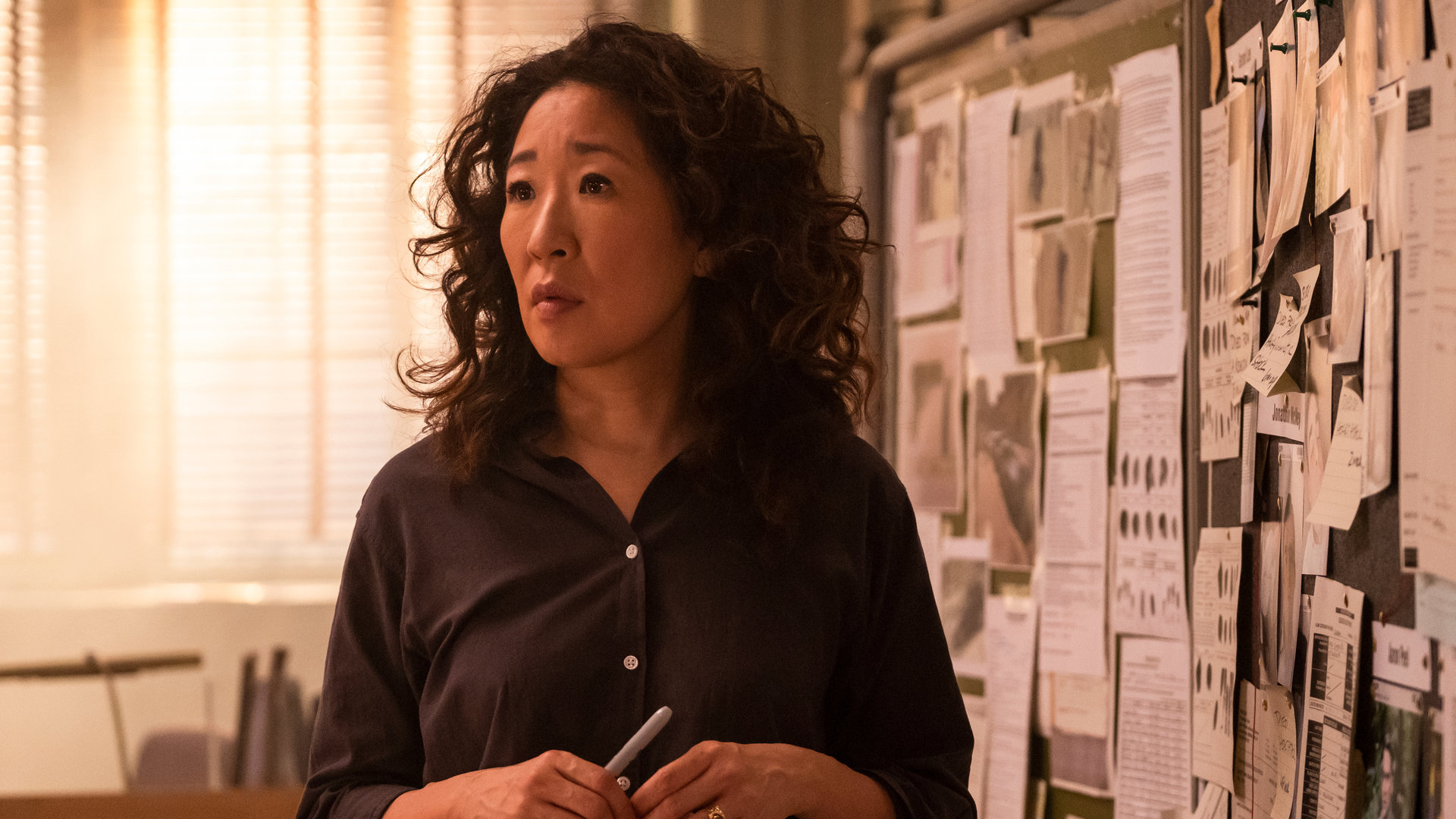 "Killing Eve – Post aus Amsterdam": Eve (Sandra Oh) steht vor einer Pinnwand voller Zettel und schaut nachdenklich in die Ferne.