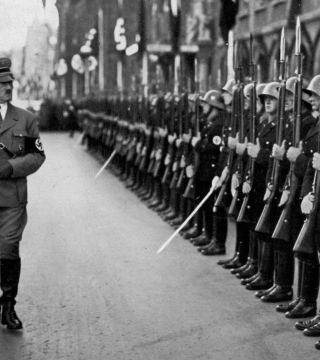 "Terra X History - SS - Macht und Mythos". Historisches Schwarz-Weiß-Foto: Hitler läuft an einer Reihe Soldaten entlang.