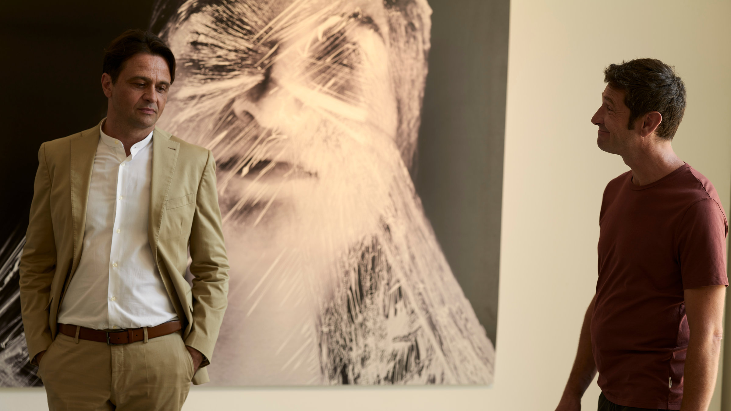 "SOKO Wien - Geliebter Mörder": Bezirksinspektor Klaus Lechner (Andreas Kiendl) steht zusammen mit Galerist Uwe Springer (Michael Rotschopf) vor einem Bild. Auf dem Bild ist der Kopf einer Frau zu sehen, der in Frischhaltefolie eingewickelt ist.