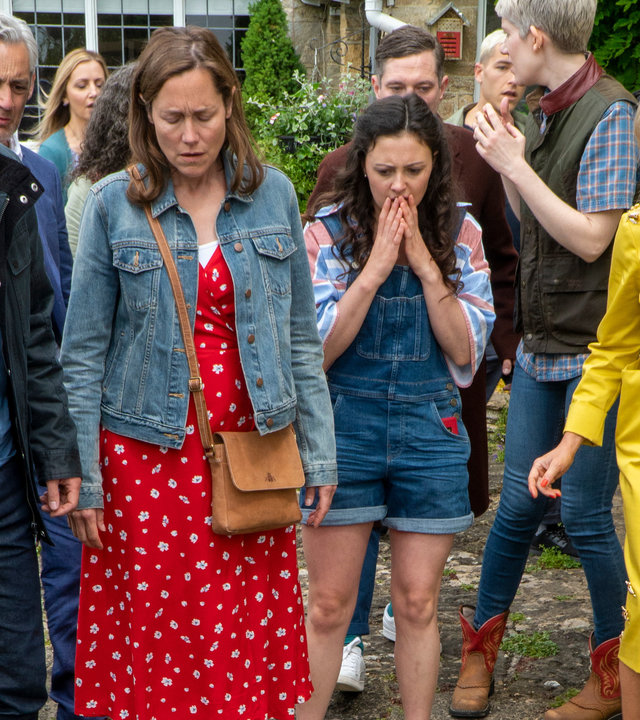 "Agatha Raisin - Und das tödliche Kirchenfest Teil 2": Agatha (Ashley Jensen), Toni (Jodie Tyack), Sarah (Lucy Liemann) und D.S. Bill Wong (Matt McCooey) stehen vor einer Menschenmenge und schauen erschüttert auf den Boden.