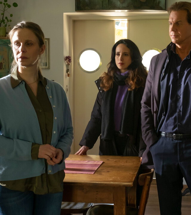 "Der Alte - Blume des Bösen": Tanja Höhmann (Julia Jäger) steht betrübt in ihrem Wohnzimmer. Sie dreht dabei Annabell Lorenz (Stephanie Stumph) und Caspar Bergmann (Thomas Heinze) den Rücken zu.
