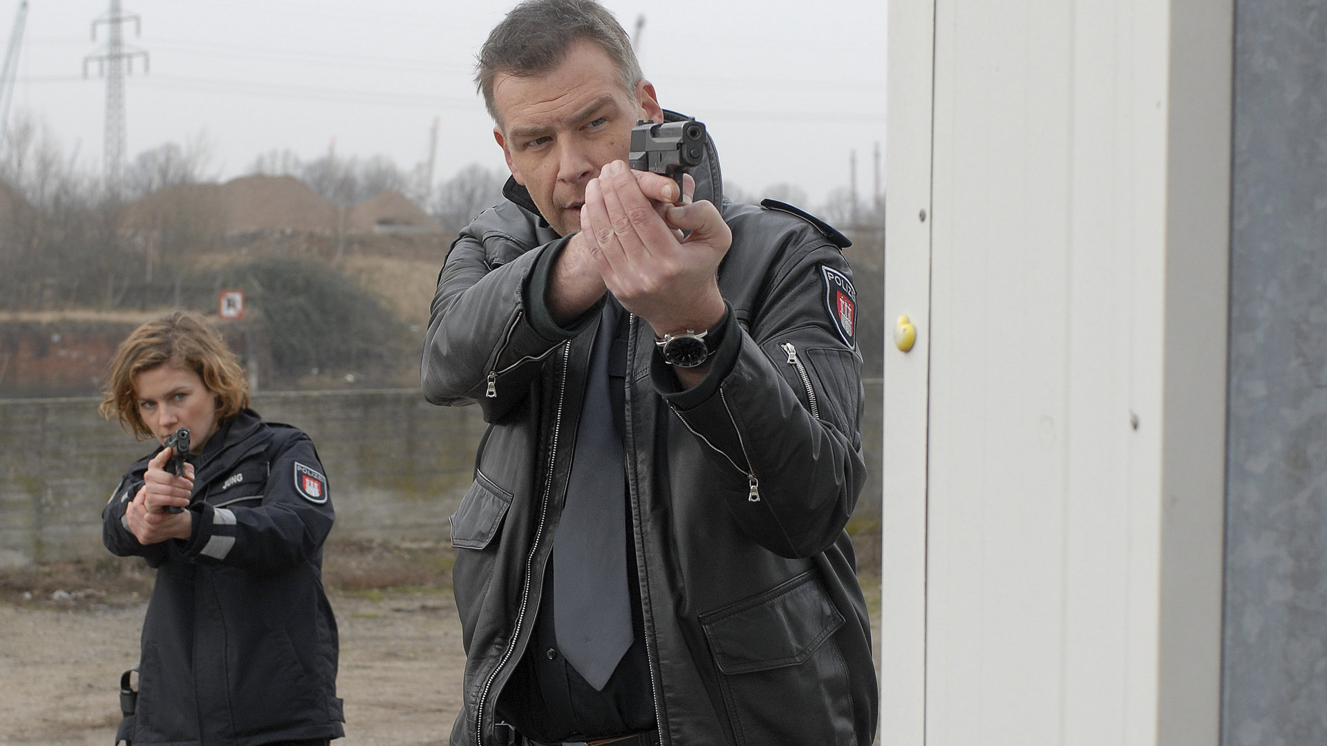"Notruf Hafenkante - Erschütterungen": Franzi (Rhea Harder) und Boje (Frank Vockroth) stehen hintereinander mit gezogenen Waffen.