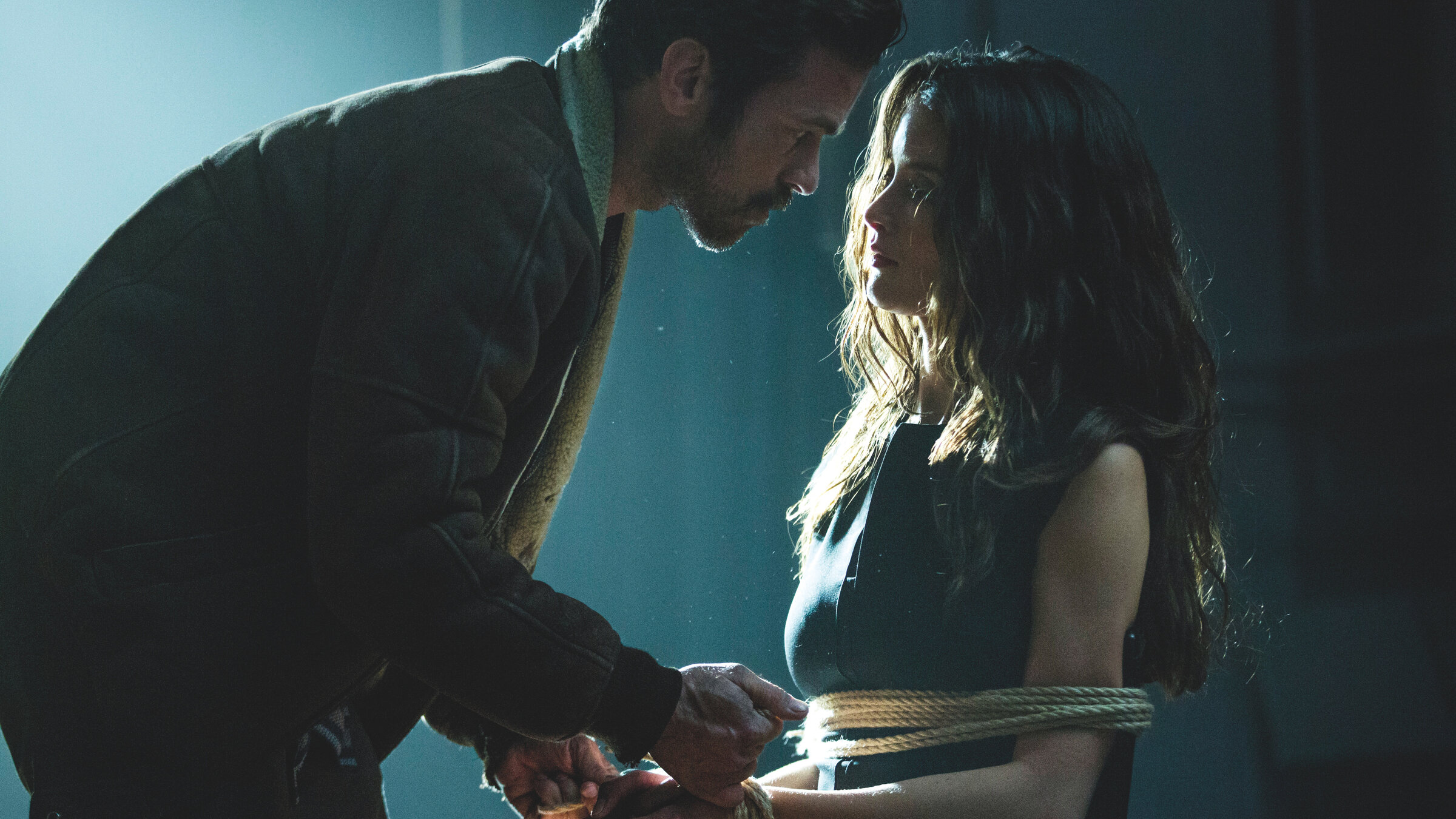 "Iris - Rendezvous mit dem Tod": Claudia (Charlotte Le Bon) sitzt auf einem Stuhl und wird von Max (Romain Duris) an diesen gefesselt. Dabei schauen sie sich in die Augen.