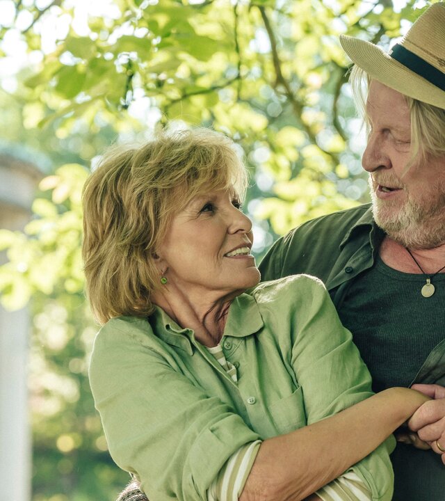 "Petra geht baden": Im Freien vor einem Gebäude: Petra (Ulrike Kriener) und Erik (Rolf Lassgård) tanzen und blicken sich dabei in die Augen.